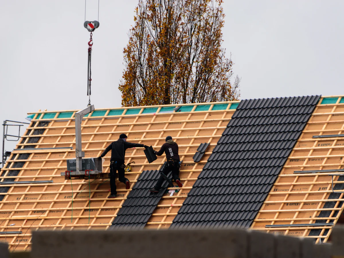 Dakdekkers leggen dakpannen op een nieuw dak